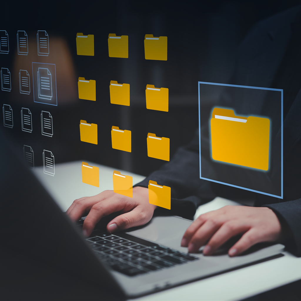 Une personne tapant sur un ordinateur portable avec des icônes de dossiers jaunes numériques flottant au-dessus du clavier, symbolisant la gestion de fichiers ou l'organisation de données sur un ordinateur.