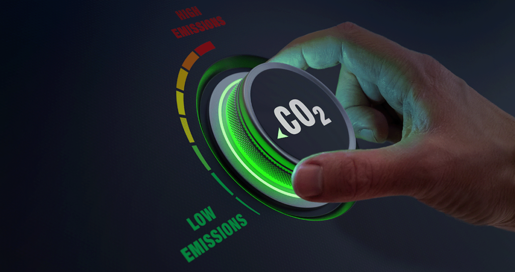 Une aiguille fait tourner un cadran étiqueté CO2, passant de la zone rouge à fortes émissions à la zone verte à faibles émissions, symbolisant la réduction des émissions de dioxyde de carbone.
