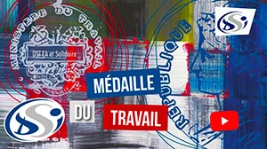 Arrière-plan abstrait avec coups de pinceau bleus, rouges et gris. Le texte « Médaille du Travail » est superposé. Les logos et sceaux officiels du gouvernement français côtoient le logo DSI et une icône de lecture YouTube bien visible.