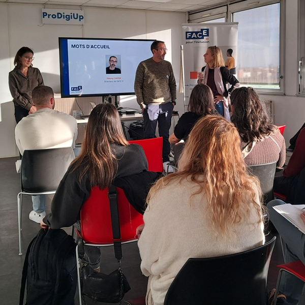 Un groupe de personnes assises dans une salle écoute trois présentateurs debout près d'un écran affichant des "Mots d'Accueil" et une photo. La lumière du soleil traverse les fenêtres, éclairant le public et les présentateurs.